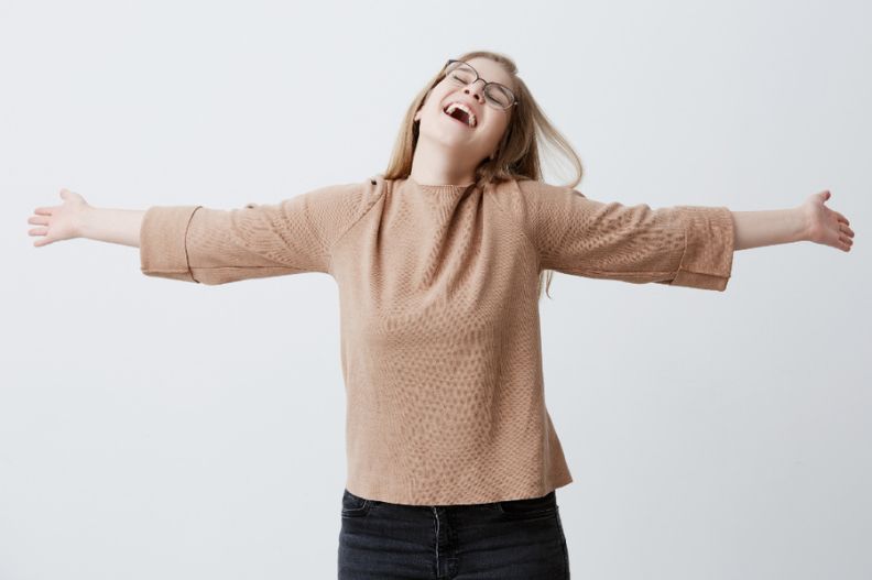 mujer con los brazos extendidos muy feliz